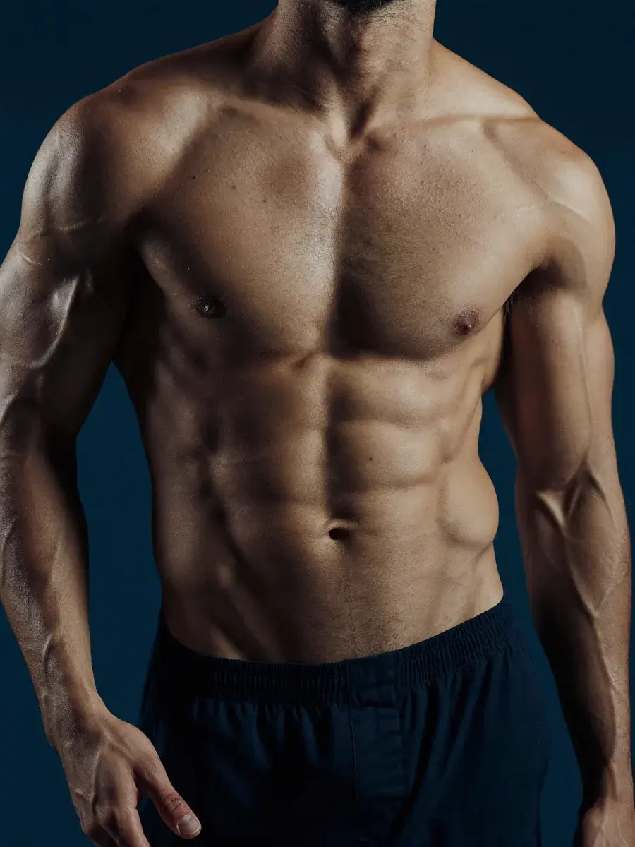A fit, healthy physique against deep navy — Stilwell Wellness Solutions hormone optimization for men.